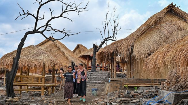Pemandu wisata berbincang dengan wisatawan asing saat berkunjung ke Desa wisata adat Sade, Rembitan, Kecamatan Pujut, Praya, Lombok Tengah, NTB, Rabu (28/10/2026). [ANTARA FOTO/Ahmad Subaidi/nz]
