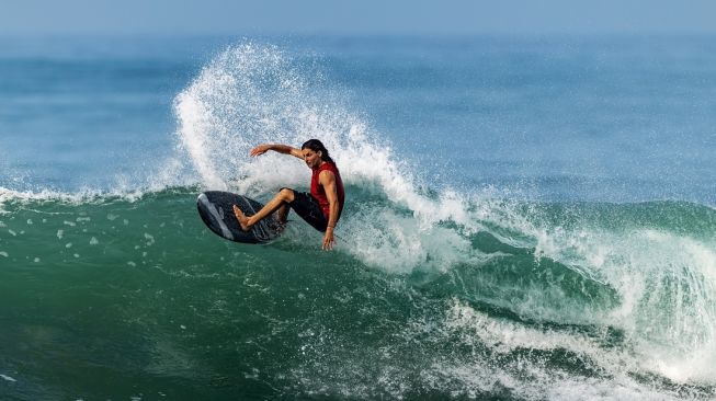 Salah seorang peselancar unjuk kebolehan di sebuah pantai di Bali di ajang Deus Slidetober 2026. [Deus Ex Machina] 