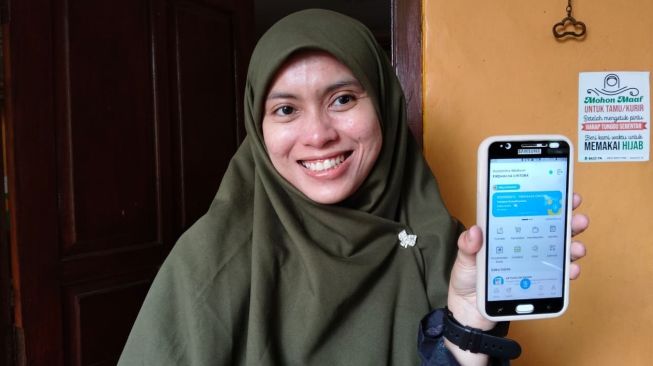 Firdha saat menunjukkan aplikasi BSya yang dia gunakan selama bertransaksi jual beli dagangannya. [Suara.com/Baktora]