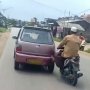 Kakinya Sekuat Kuda, Pria Ini Sanggup Dorong Mobil Mogok dari Atas Motor