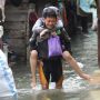 Perjuangan Suami Gendong Istrinya Melewati Banjir