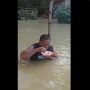 Kelewat Santuy! Pria Ini Makan di Tengah Banjir