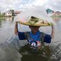 Perjuangan Seorang Bocah Terobos Banjir Demi Berjualan Kue