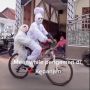 Kreatif! Pengamen Ini Cosplay Jadi Pocong Sambil Sepedaan dan Bonceng 'Anak'