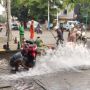 Kocak! Bapak-Bapak Cuci Motor Pakai Air dari Bocoran Pipa di Jalan, Warganet: Tetap Santai dan Manfaatkan Keadaan