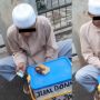 Tak Lupa Tuhan, Pemuda ini Tetap Menyempatkan Baca Al-Quran saat Jongkok Berjualan Donat di Pinggir Jalan