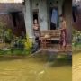 Banjir di Depan Rumah, Pria Ini Malah Asyik Jaring Ikan