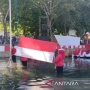 Unik, Warga Sumenep Rela Basah-basahan Upacara Bendera di Tengah Sungai