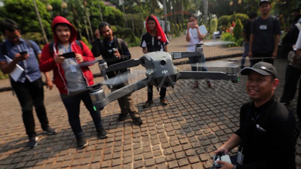 Peserta mencoba menerbangkan Kamera drone Mavic 2 zoom di Taman Cattleya, Jakarta Barat, Jumat (12/10).  
[Suara.com/Muhaimin A Untung]  
