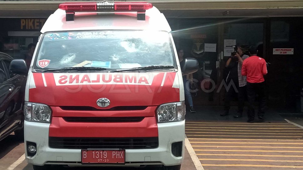 Wartawan mengambil gambar mobil ambulans milik Pemprov DKI Jakarta yang ditahan di Halaman Polda Metro Jaya, Jakarta, Kamis (26/9). [Suara.com/Arga]
