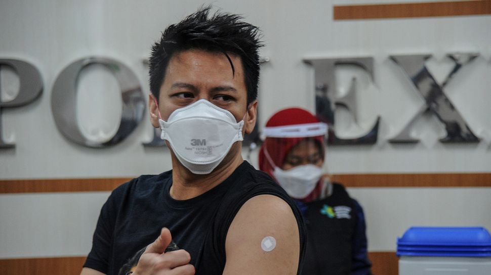 Influencer dan musisi asal Bandung, Nazril Ilham alias Ariel Noah menunjukan lengan yang telah disuntikkan vaksin COVID-19 di RSKIA Kota Bandung, Jawa Barat, Kamis (28/1/2021).  [ANTARA FOTO/Raisan Al Farisi]