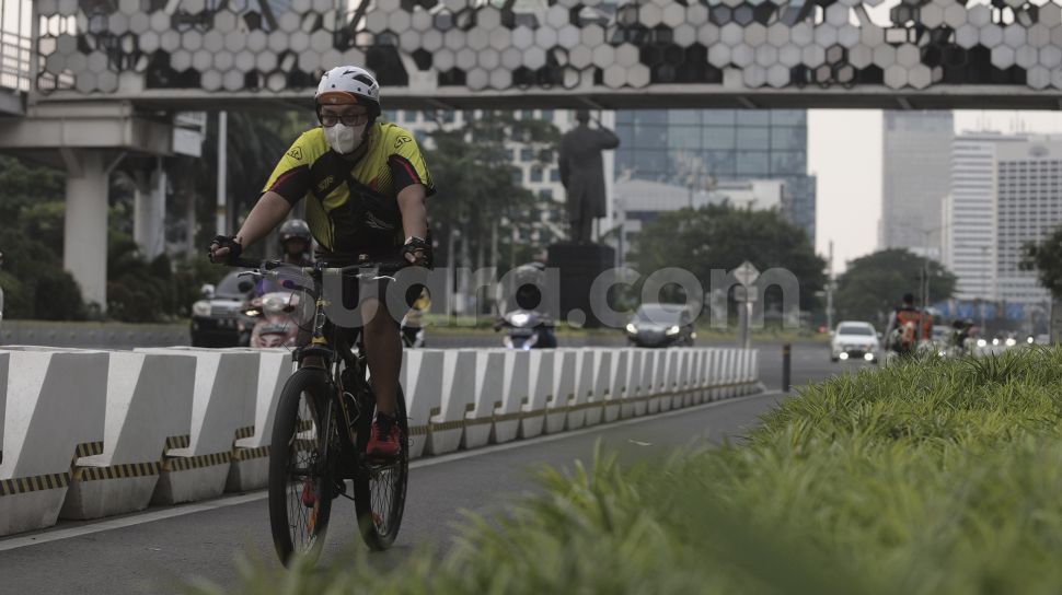 Pesepeda melintasi jalur khusus sepeda di Jalan Jenderal Sudirman, Jakarta, Sabtu (5/6/2021). [Suara.com/Angga Budhiyanto]