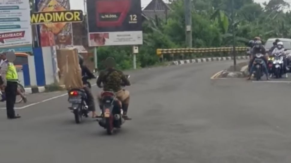 Viral pemotor tanpa helm yang lolos dari hadangan aparat. (Facebook)