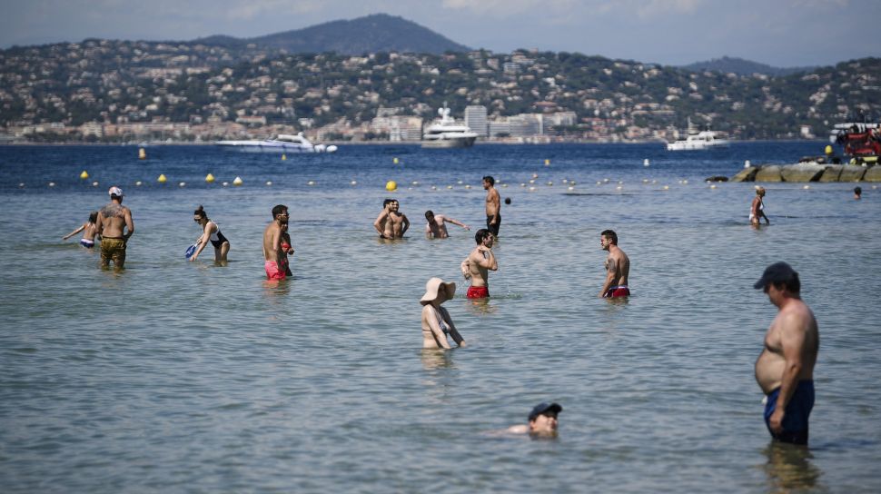 Orang-orang mengunjungi pantai La Bouillabaisse setelah Prancis baru-baru ini melonggarkan tindakan pencegahan penyebaran COVID-19 di Ramatuelle, Saint-Tropez, Prancis, pada (10/7/2021). [CLEMENT MAHOUDEAU / AFP]