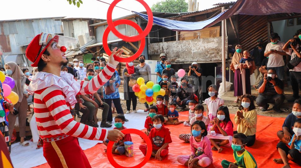 Badut yang tergabung dalam komunitas Aku Badut Indonesia (ABI) menghibur anak-anak di pengungsian korban kebakaran di Jl. Kemang Utara IX, Jakarta Selatan, Rabu (18/8/2021). [Suara.com/Alfian Winanto]