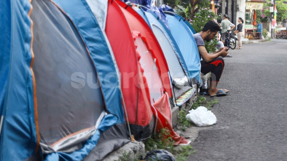 Pencari Suaka asal Afghanistan beraktivitas di depan tendanya di Kebon Sirih, Jakarta Pusat, Sabtu (28/8/2021). [Suara.com/Alfian Winanto]