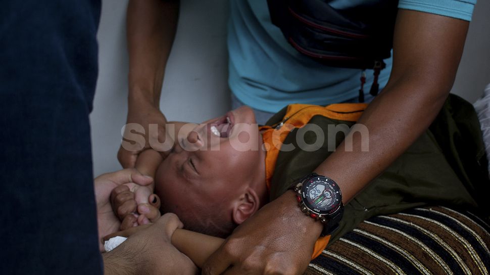Ekspresi seorang anak saat mengikuti sunatan massal yang digelar di Binong Permai, Kabupaten Tangerang, Banten, Sabtu (25/9/2021). [Suara.com/ Hilal Rauda Fiqry]