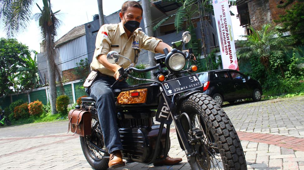Kepala Sekolah Cone Kustarto menaiki purwarupa sepeda motor listrik hasil inovasinya di SMKN 5 Malang, Jawa Timur, Jumat (29/10/2021). ANTARA FOTO/Ari Bowo Sucipto