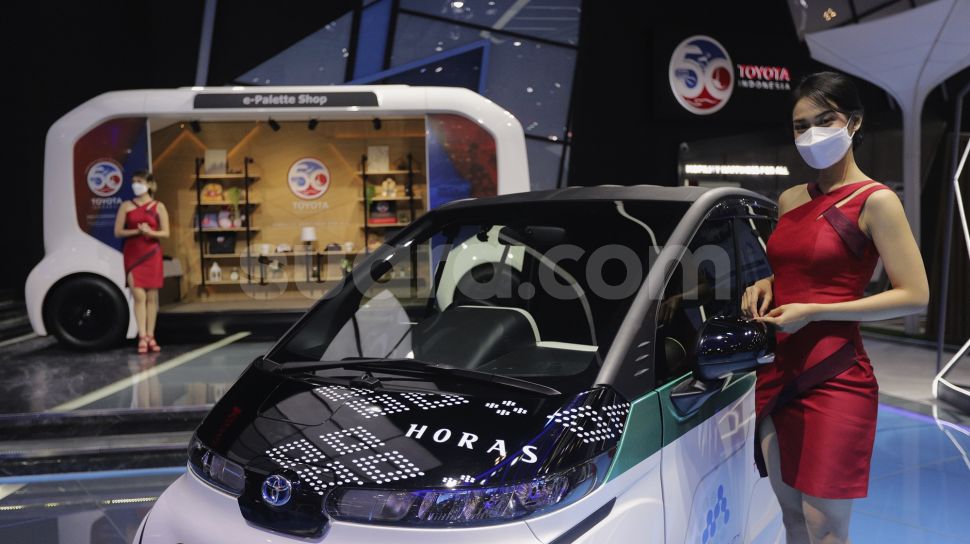 Model berpose di samping kendaraan yang dipamerkan di pameran otomotif GAIKINDO Indonesia International Auto Show (GIIAS) 2021 di Indonesia Convention Exhibition (ICE) BSD, Serpong, Tangerang, Banten, Kamis (11/11/2021). [Suara.com/Angga Budhiyanto]