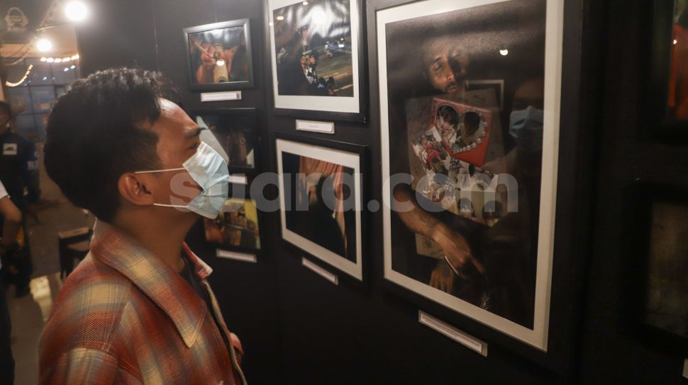 Sejumlah pengunjung melihat foto-foto yang ditampilkan pada pameran foto &#039;Anglocita&#039; di Depok, Jawa Barat, Minggu (21/11/2021). [Suara.com/Alfian Winanto]