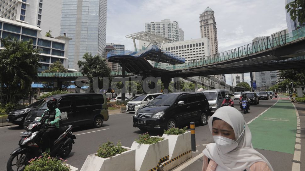 Sejumlah kendaraan melintas di dekat proyek revitalisasi Jembatan Penyeberangan Orang (JPO) Sudirman di Jakarta, Selasa (23/11/2021). [Suara.com/Angga Budhiyanto]
