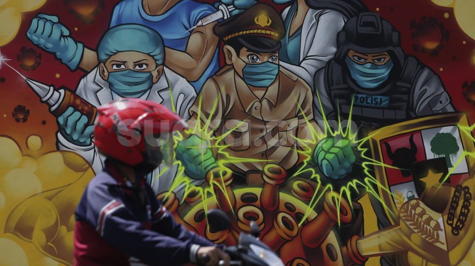 Pengendara sepeda motor melintas di depan mural bertema COVID-19 di Jakarta, Jumat (26/11/2021). [Suara.com/Angga Budhiyanto]