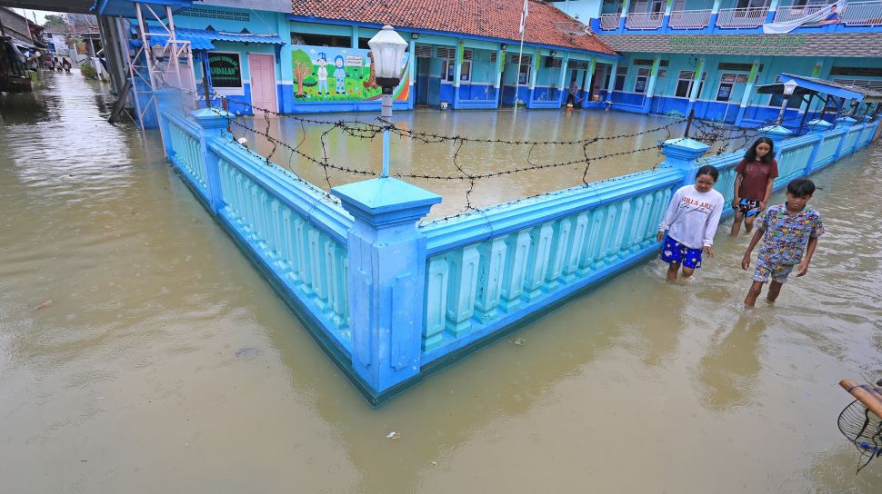Warga melintasi banjir rob yang melanda desa Eretan Wetan, Kandanghaur, Indramayu, Jawa Barat, Sabtu (4/12/2021). ANTARA FOTO/Dedhez Anggara