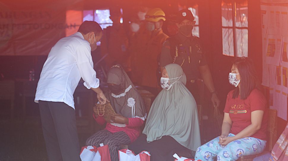 Presiden Joko Widodo (kiri) mengunjungi korban bencana Gunung Semeru di posko pengungsian Desa Sumberwuluh, Candipuro, Lumajang, Jawa Timur, Selasa (7/12/2021).  ANTARA FOTO/Seno