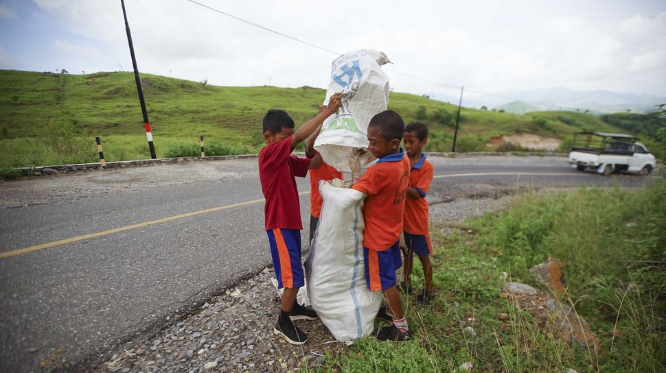 Sejumlah siswa SD Katolik Supilape mengumpulkan sampah plastik dan bekas popok yang dibuang di Jalan Trans Flores, Mbay, Kabupaten Nagekeo, NTT, Sabtu (8/1/2022). [ANTARA FOTO/Ignas Kunda]