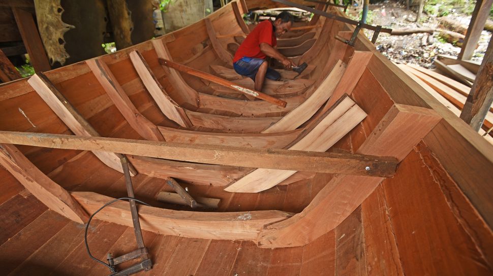 Pekerja menyelesaikan pembuatan perahu tradisional di Kampung Kendang, Margaluyu, Serang, Banten, Selasa (18/1/2022).  ANTARA FOTO/Asep Fathulrahman