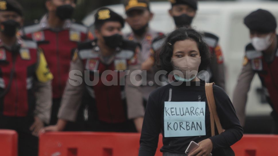 Massa yang tergabung dalam Jaringan Solidaritas Korban untuk Keadilan (JSKK) melakukan aksi Kamisan Ke-714 di seberang Istana Merdeka, Jakarta, Kamis (20/1/2022). [Suara.com/Angga Budhiyanto]