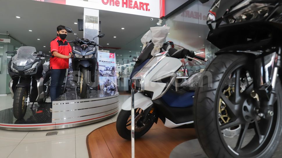 Petugas membersihkan sepeda motor yang di panjang di salah satu dealer di kawasan Pasar Minggu, Jakarta Selatan, Minggu (23/1/2022). [Suara.com/Alfian Winanto]