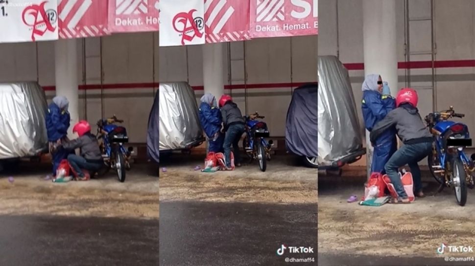 Salut! Suami Ini Pakaikan Jas Hujan ke Istri yang Lagi Gendong Anak