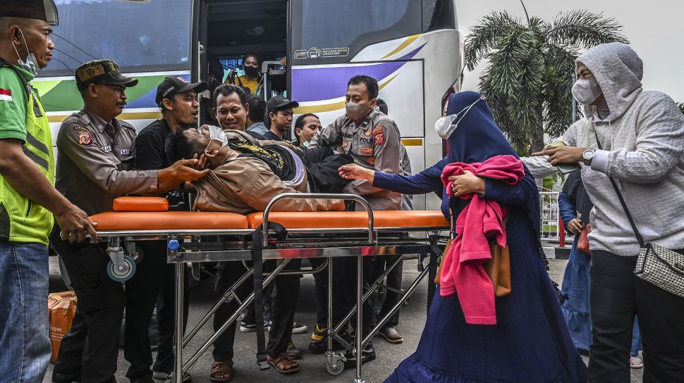 Petugas kepolisian bersama pemudik membantu membaringkan jenazah seorang penumpang bus Sinar Jaya yang meninggal dunia di kawasan Simpang Jomin, Karawang, Jawa Barat, Sabtu (30/4/2022).  ANTARA FOTO/Muhammad Adimaja
