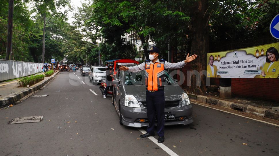 Petugas mengatur kendaraan saat melakukan uji coba rekayasa lalu lintas di sekitar kawasan Tebet Eco Park, Jakarta Selatan, Senin (16/5/2022). [Suara.com/Alfian Winanto]
