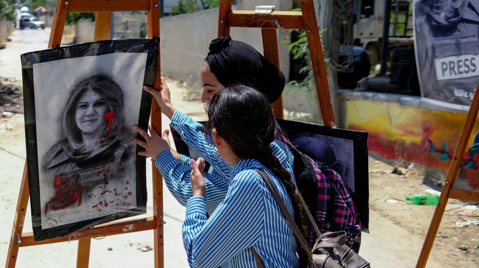 Dua gadis menghadiri pameran seni yang digelar untuk menghormati mendiang jurnalis Al-Jazeera Palestina, Shireen Abu Akleh di kota Jenin, Palestina, Kamis (19/5/2022). [RONALDO SCHEMIDT / AFP]