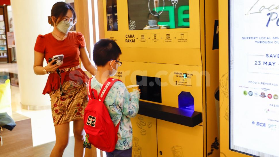 Calon pembeli berbelanja menggunakan vending machine di Grand Indonesia, Jakarta Pusat, Selasa (24/5/2022). [Suara.com/Alfian Winanto]