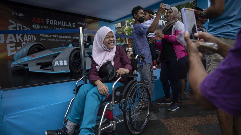 Sejumlah warga menyaksikan replika mobil balap listrik Formula E yang dipamerkan saat hari bebas kendaraan bermotor di Bundaran HI, Jakarta, Minggu (29/5/2022).  ANTARA FOTO/Sigid Kurniawan