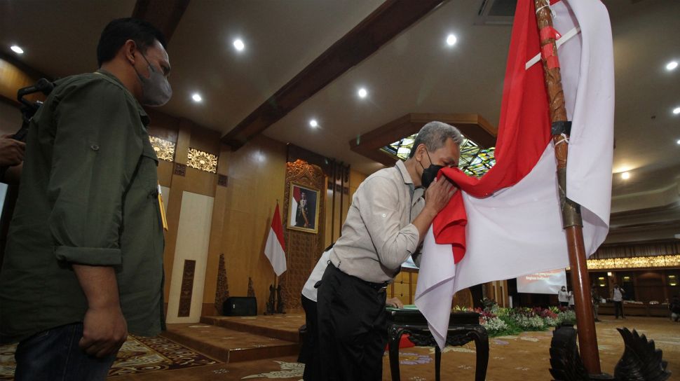 Salah satu mantan anggota Jamaah Islamiyah (JI) mencium bendera Merah Putih saat melakukan ikrar setia kepada NKRI dan Pancasila serta melepas baiat (janji taat) kepada JI di Kantor Gubernur Jawa Timur di Surabaya, Jawa Timur, Senin (8/8/2022).  ANTARA FOTO/Moch Asim