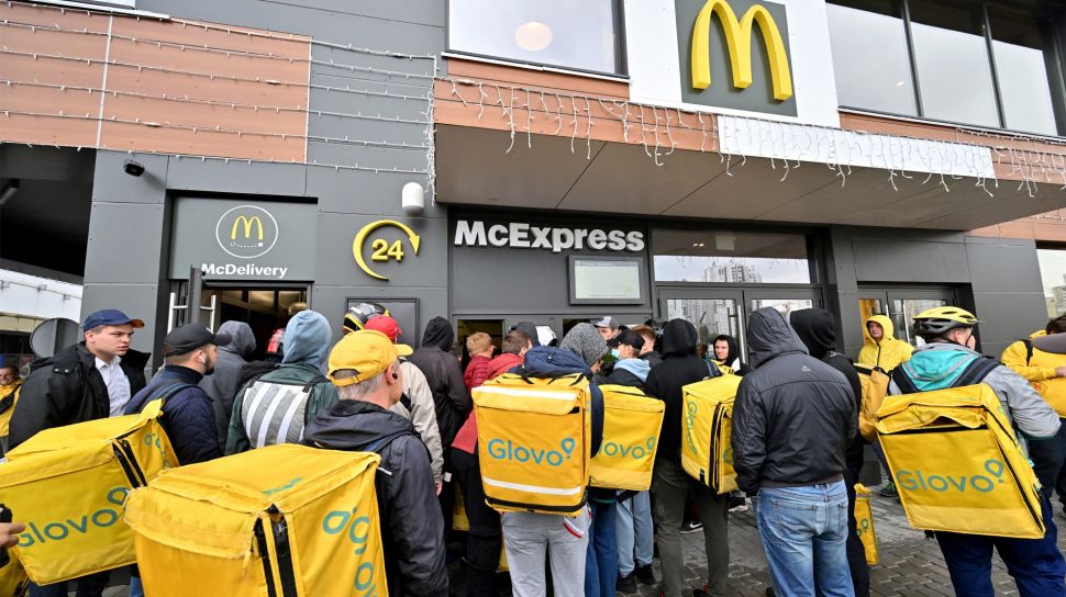 Kurir pengiriman makanan Glovo menunggu untuk mengambil pesanan di luar restoran McDonald di Kyiv, Ukraina, Selasa (20/9/2022). [Sergei SUPINSKY / AFP]
