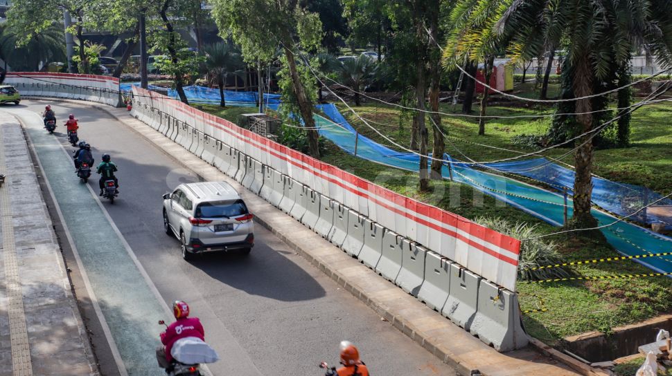 Kendaraan melintas di dekat pembangunan jalur sepeda di kawasan Semanggi, Jakarta Pusat, Sabtu (24/9/2022). [Suara.com/Alfian Winanto]