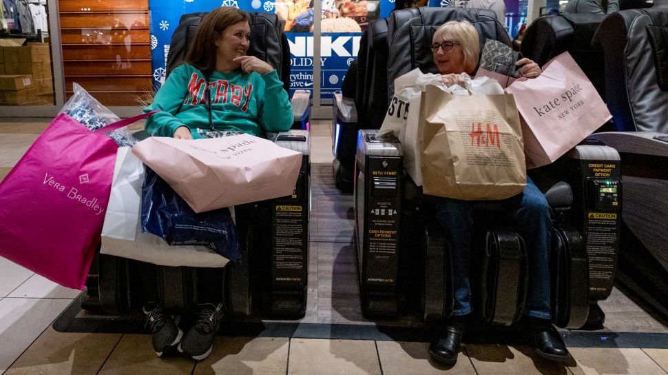 Para pembeli Black Friday beristirahat sejenak di kursi pijat di Opry Mills Mall di Nashville, Tennessee, Amerika Serikat, Jumat (25/11/2022). [SETH HERALD/AFP]