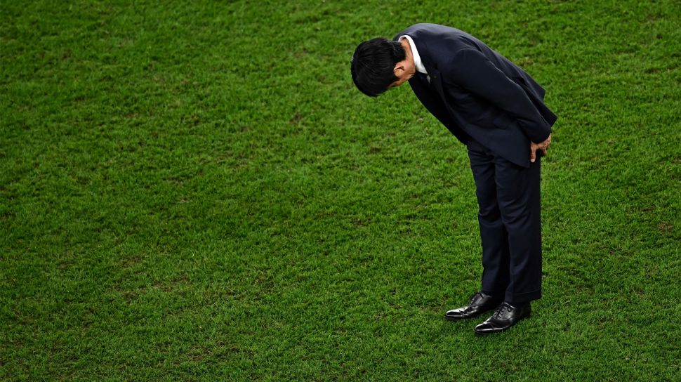 Pelatih Jepang Hajime Moriyasu membungkuk setelah kalah dalam pertandingan sepak bola babak 16 besar Piala Dunia 2022 antara Jepang dan Kroasia di Stadion Al-Janoub di Al-Wakrah, selatan Doha, Qatar, Senin (5/12/2022). [Anne-Christine POUJOULAT / AFP]