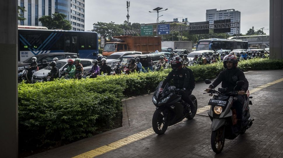 Pengendara sepeda motor melintas di atas trotoar Jalan Gatot Subroto, Jakarta, Senin (6/3/2023). [ANTARA FOTO/Aprillio Akbar].