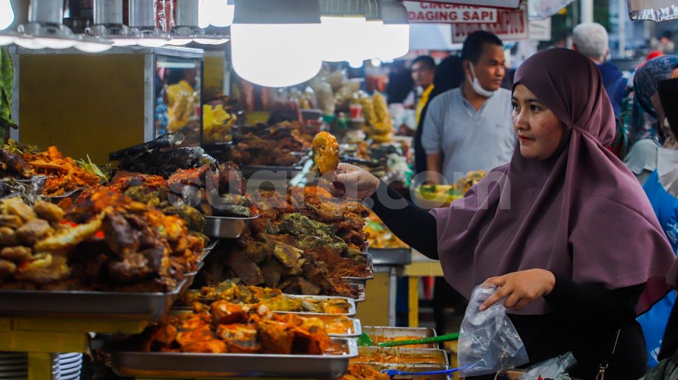 Pengunjung memilih menu berbuka puasa di Sentra kuliner Nasi Kapau di Jalan Kramat Raya, Senen, Jakarta Pusat, Jumat (24/3/2023). [Suara.com/Alfian Winanto]