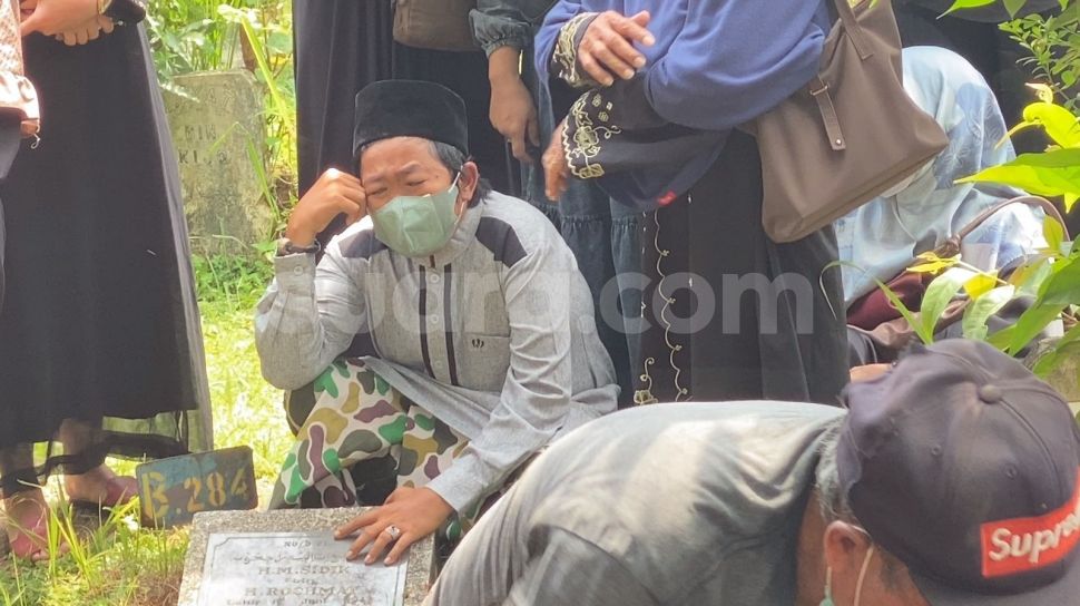Adul menangis di pemakaman sang ibu di TPU Kramat Pela, Kebayoran Baru, Jakarta Selatan, Sabtu (25/3/2023). [Adiyoga Priyambodo/Suara.com]