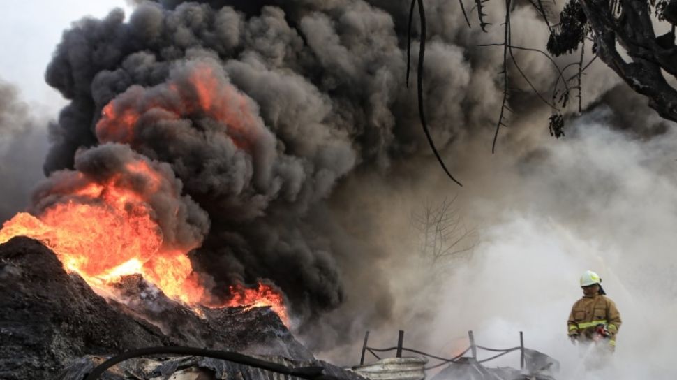 Petugas berusaha memadamkan api yang membakar pabrik plastik di Kalideres, Jakarta Barat, Jumat (19/5/2023). [ANTARA FOTO/Fauzan].