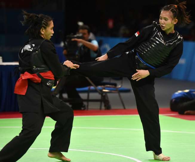 Pesilat putri Indonesia Wewey Wita (kanan) bertarung melawan pesilat Filipina Clyde Joy Baria pada semifinal Pencak Silat nomor Tanding Putri 55-60 kg Sea Games Singapura, Sabtu (13/6) [Antara/Wahyu Putro A]