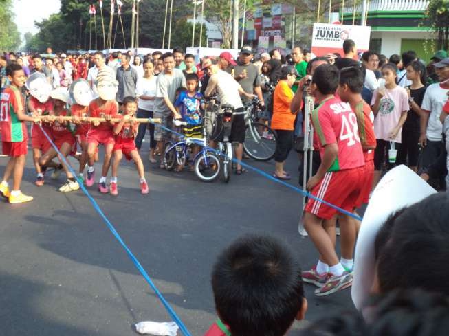 Puluhan siswa SSB Bonansa Solo saat mengikuti lomba tarik tambangbambu gila di Jalan Slamet Riyadi Solo, Jawa Tengah, Minggu (16/8/2015). [suara.com/Labib Zamani]