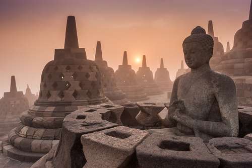 Matahari pagi terlihat di antara stupa-stupa Candi Borobudur, Magelang, Jawa Tengah (Shutterstock).